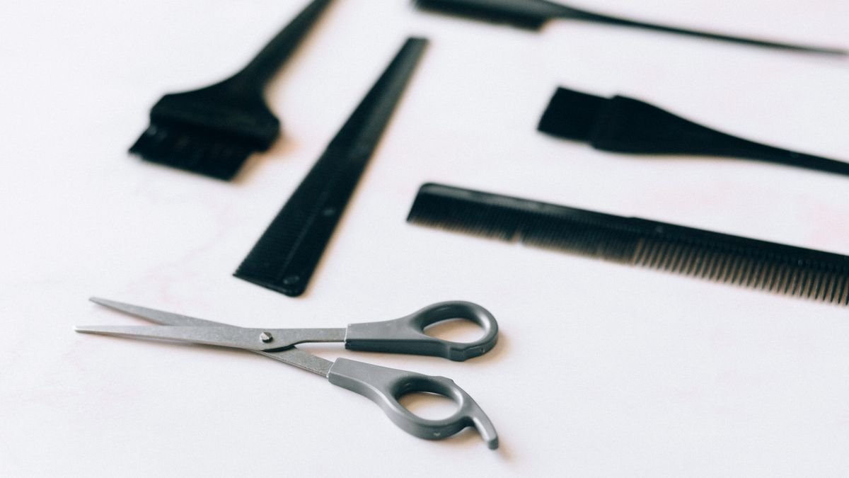 Frascos e ferramentas de cuidado com o cabelo sobre um fundo claro