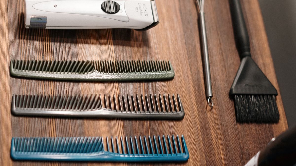 Pente e ferramentas de cabelo organizados sobre uma mesa de madeira