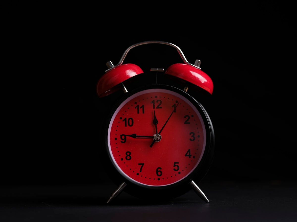Despertador vermelho em ambiente escuro, representando sono ruim e queda de testosterona